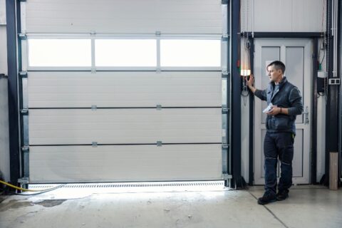 Technician checking garage door opener for seasonal garage door care in Chicago, IL