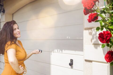 Homeowner checking garage door while troubleshooting sensor alignment and operation